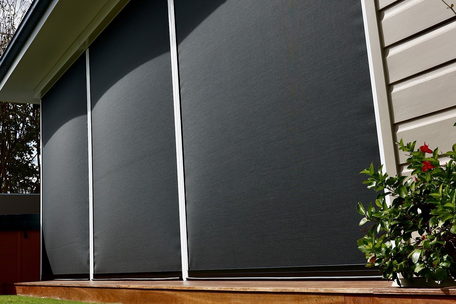 Charcoal zip screens on a weatherboard home deck